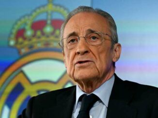 Homme en costume devant logo du Real Madrid