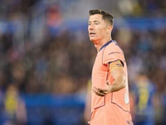 Joueur de football en maillot orange sur terrain