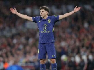Footballeur en maillot bleu bras écartés