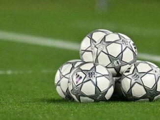 Ballons de football empilés sur pelouse verte