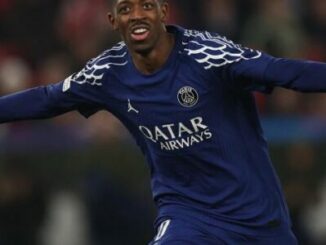 Footballeur en maillot bleu célébrant un but
