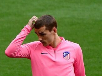 Footballeur en maillot rose se grattant la tête