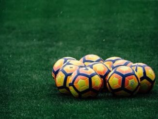 Ballons de football sur pelouse verte