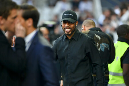 Homme souriant en casquette noire dans un stade