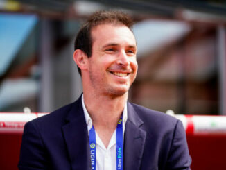 Homme souriant en veste lors d’un événement sportif