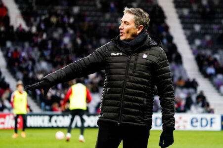 Homme en veste noire sur terrain de football