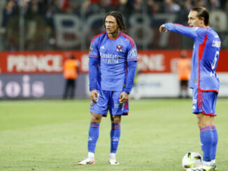 Deux footballeurs en maillot bleu sur le terrain