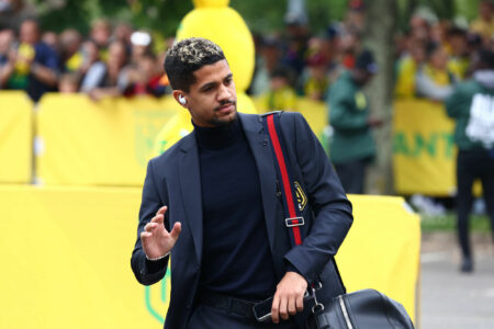 Homme en costume noir saluant la foule