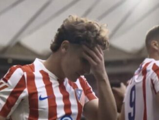 Footballeur en maillot rouge et blanc, tête baissée