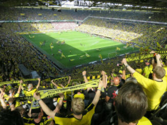 Stade de football rempli de supporters jaunes et noirs