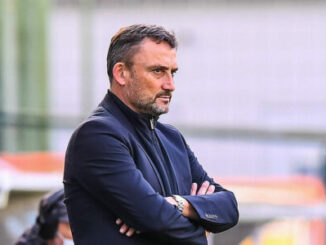 Homme sérieux bras croisés sur terrain de football