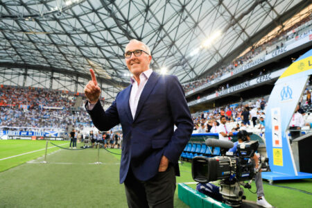 Homme en costume saluant dans un stade