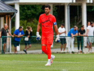 Gardien de but en tenue orange sur le terrain