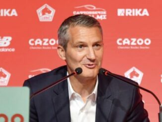 Homme en conférence de presse devant logos rouges