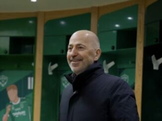 Homme souriant dans vestiaire aux casiers verts