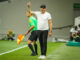 Entraîneur de football levant le bras sur la touche
