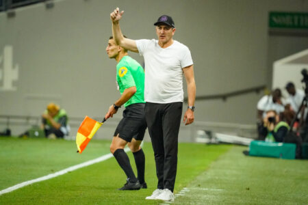 Entraîneur de football gesticulant sur le bord du terrain